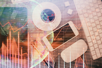 Multi exposure of forex graph hologram over desktop with phone. Top view. Mobile trade platform...