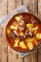 Bonava is a traditional lamb and potatoes stew from Mauritania closeup in a bowl on the table. Vertical top view from above