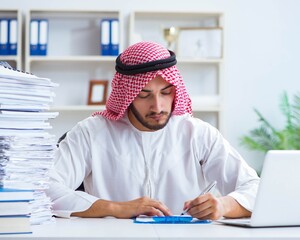 Arab businessman working in the office doing paperwork with a pi