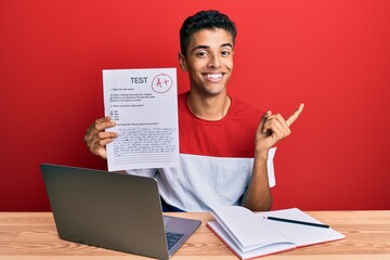 Young handsome african american man showing a passed exam smiling happy pointing with hand and finger to the side