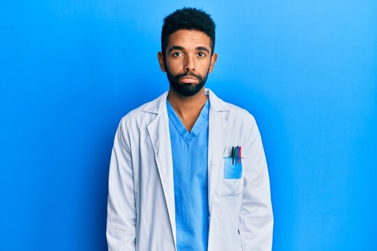 Handsome hispanic man with beard wearing doctor uniform depressed and worry for distress, crying angry and afraid. sad expression.