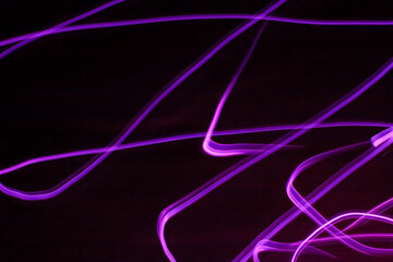 Long exposure pink lights abstract texture background. Pink lights drawing patterns on black background.