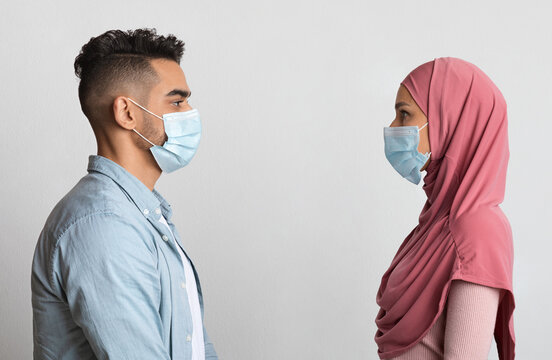 Social Distancing Concept. Profile Shot Of Muslim Couple In Protective Medical Masks