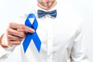 Cancer people. Hipster men in bright shirt, cyan bowtie with blue ribbon in hands on white background. Awareness prostate cancer of men health. Man Healthcare and World cancer day concept.