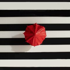 Red umbrella on a black and white background. Creative concept, geometric shapes in bold colors.
