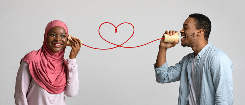 Young Black Muslim Couple With Can Phone On Grey Background