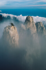 three mountain peaks above the white clouds