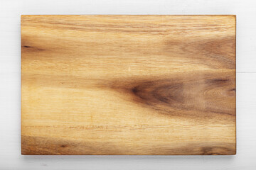 Cutting wooden board of rectangular shape on a wooden background.  Space for text.