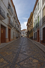 Fototapeta na wymiar A narrow decoratively cobbled Street in the medieval town of Antequerra in Andalucia on a quiet evening in May.