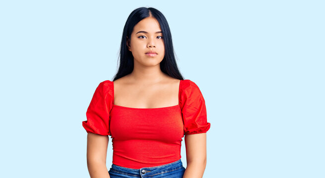 Young beautiful asian girl wearing casual clothes relaxed with serious expression on face. simple and natural looking at the camera.