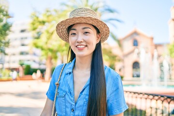 Young chinese tourist woman smiling happy walking at street of city.