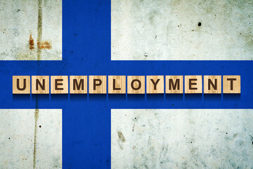 Unemployment. The inscription on wooden blocks on the background of the Finland flag. Unemployment growth. Business.