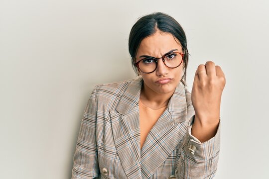 Young brunette woman wearing business jacket and glasses doing italian gesture with hand and fingers confident expression