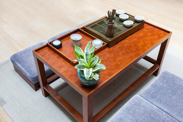 Potted plant and tea set on the wooden table in a modern Chinese tradition tea room.
