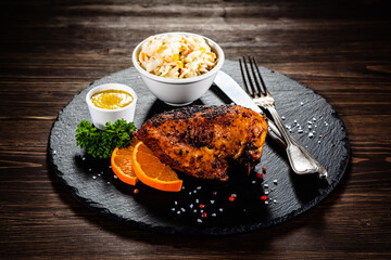 Stuffed chicken breast and coleslaw on wooden table
