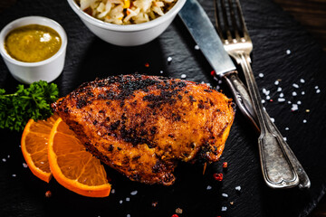 Stuffed chicken breast and coleslaw on wooden table
