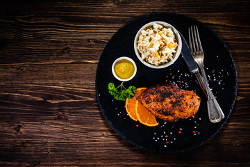 Stuffed chicken breast and coleslaw on wooden table
