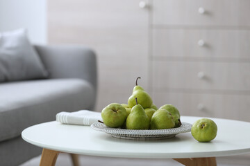 Fresh ripe pears on white table in room