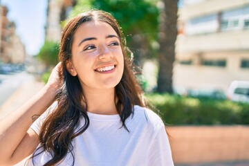 Young hispanic woman smiling happy walking at the city.