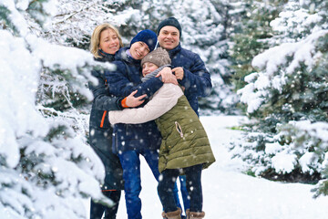 Fototapeta na wymiar family portrait in the winter forest, parent and children, beautiful nature with bright snowy fir trees
