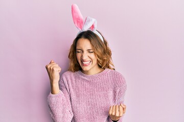 Young caucasian woman wearing cute easter bunny ears celebrating surprised and amazed for success...
