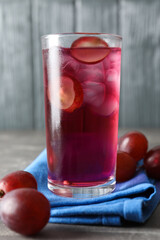 Delicious grape soda water on grey table. Refreshing drink