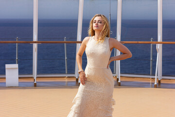 Woman in a white wedding dress on the open deck. Bride on the beach