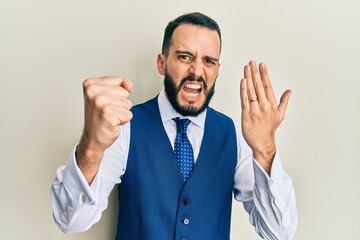 Young man with beard wearing engagement ring annoyed and frustrated shouting with anger, yelling crazy with anger and hand raised
