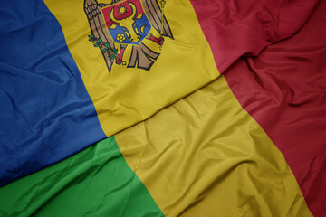 waving colorful flag of mali and national flag of moldova.