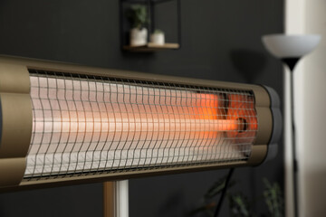 Modern electric infrared heater in room interior, closeup