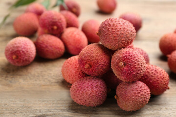Fresh ripe lychees on wooden table, closeup. space for text