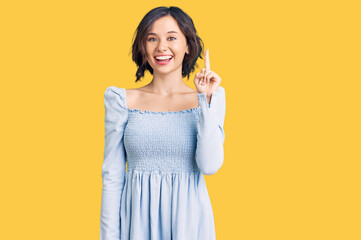 Young beautiful girl wearing casual clothes pointing finger up with successful idea. exited and happy. number one.