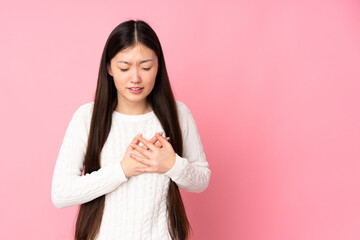 Young asian woman over isolated background having a pain in the heart