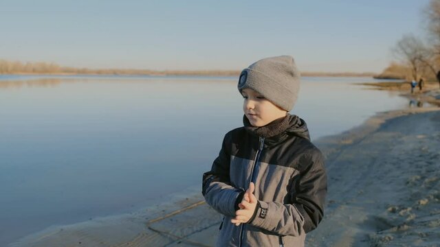 Walk on the shores of Lake Michigan. A boy walks in early spring by the lake. Spring walk with a child near the river.