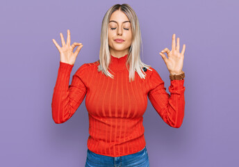 Beautiful blonde woman wearing casual clothes relaxed and smiling with eyes closed doing meditation gesture with fingers. yoga concept.