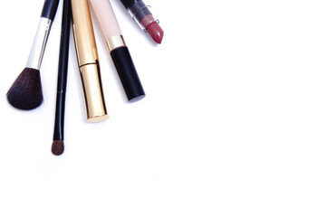 Mascara, consiler, lipstick and brushes for makeup on white background, top view