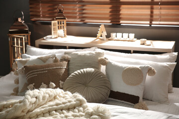 Cozy bedroom interior with knitted blanket and cushions