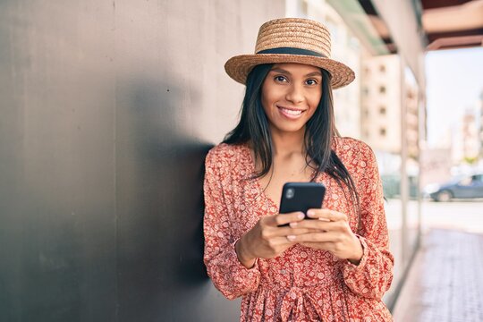 Young african american tourist woman on vacation smiling happy using smartphone at the city.