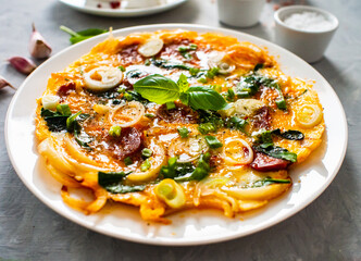 Delicious breakfast - scrambled eggs with onion and chorizo on wooden table