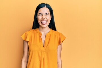 Fototapeta premium Beautiful young woman wearing casual clothes sticking tongue out happy with funny expression. emotion concept.