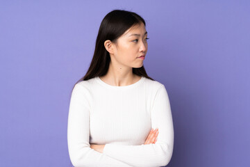 Fototapeta premium Young asian woman isolated on purple background keeping the arms crossed