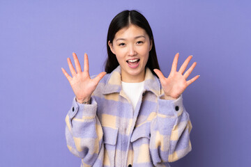 Young asian woman isolated on purple background counting ten with fingers