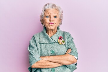 Senior grey-haired woman wearing casual clothes puffing cheeks with funny face. mouth inflated with air, catching air.