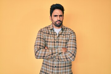 Handsome hispanic man with beard wearing casual clothes skeptic and nervous, disapproving expression on face with crossed arms. negative person.