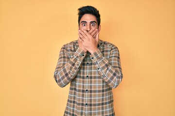 Handsome hispanic man with beard wearing casual clothes shocked covering mouth with hands for mistake. secret concept.