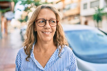 Middle age caucasian woman smiling happy standing at the city.