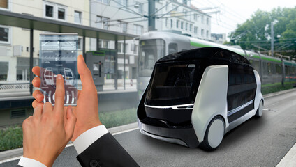Control of self driving taxi by mobile app. Hand with phone on a background of autonomous shuttle.	
