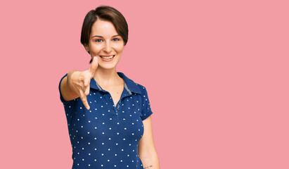 Young brunette woman with short hair wearing casual clothes smiling friendly offering handshake as greeting and welcoming. successful business.