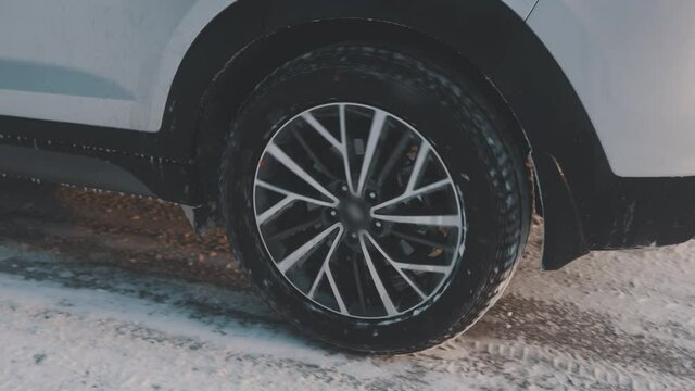Close up tire of moving car on the snowy road. Winter tires and safety on road. High quality 4k footage