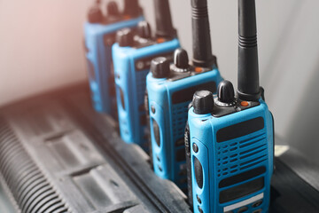 A set of blue walkie-talkies stand in a row. The concept of readiness for a rescue operation or the transmission of a stable radio communication over a distance. Copy space